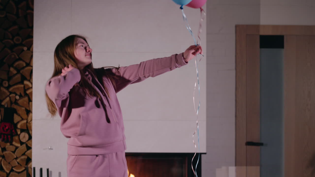 Ragazza che balla con i palloncini vicino al camino