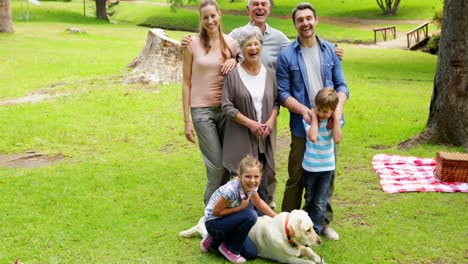 Multi-generation-family-smiling-at-camera-in-a-park