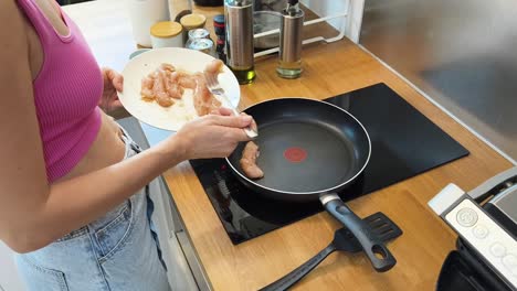 mujer cocinando pollo en la cocina