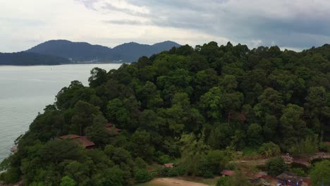 el sudeste de asia, estrecho de malaca, lumut, perak, malasia, la playa de teluk batik revela la isla de pangkor a través del agua.
