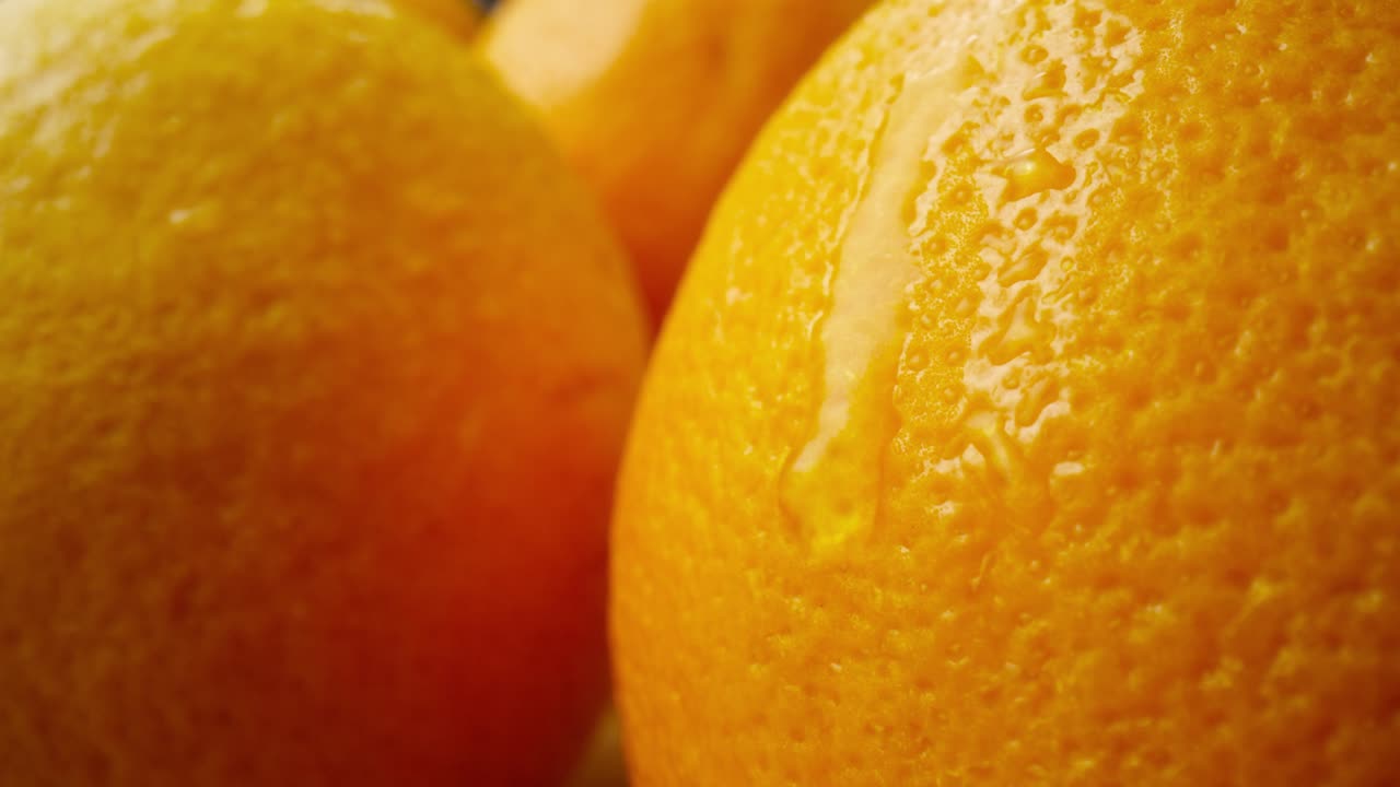 video macro de una gota de agua cayendo de la naranja.
