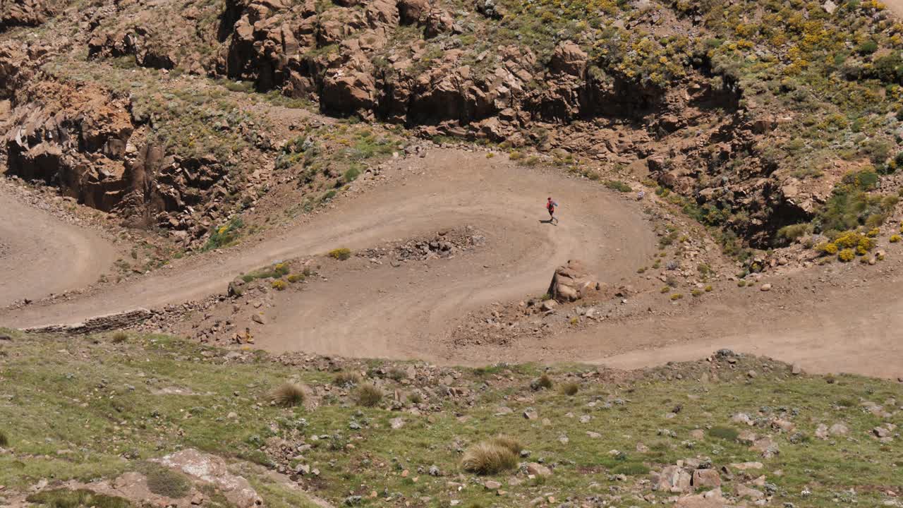 크로스 컨트리 러너는 아프리카의 사니 패스의 더트 스위치백을 조깅합니다.