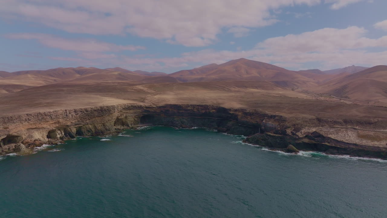 Breathtaking views of Fuerteventura with Lobos Island, Red Flag Beach, kite surfers, sunsets, volcanoes, sand dunes, and wingfoilers in the Canary Islands’ golden light.