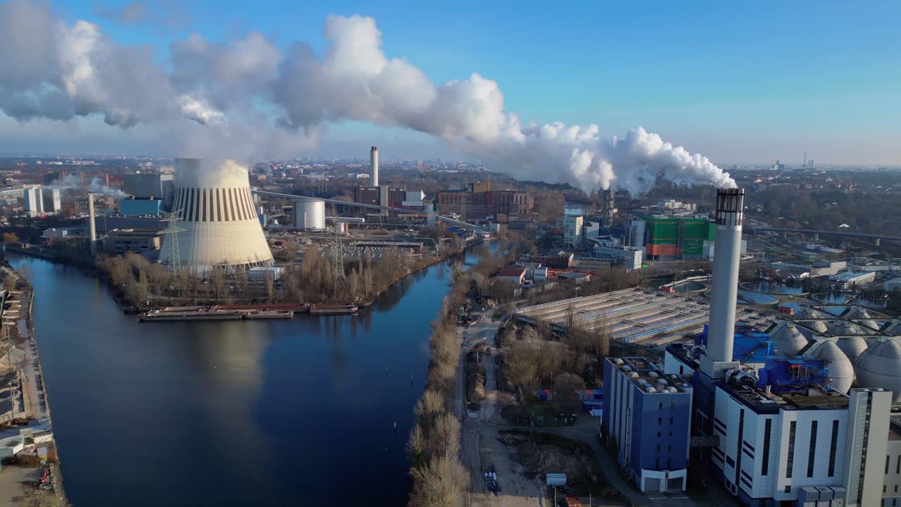 Waste to energy plant emitting smoke from its chimney, located near an urban area, environmental impact of waste. Best aerial view flight panorama overview drone