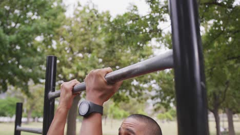 Side view man with prosthetic leg doing pull ups