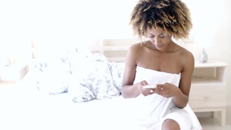 relaxed woman at home with phone on bed