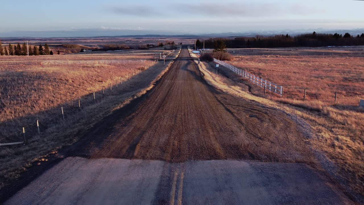 camino de tierra del país por la noche con montañas en la distancia alberta prarie