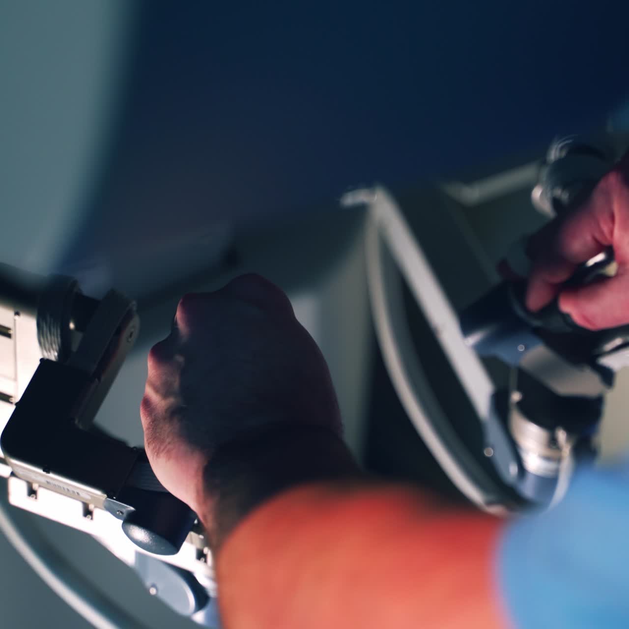Modern device in medicine. Hands of a doctor operating futuristic surgery machine. Specialist working with a surgical robot. Close-up.
