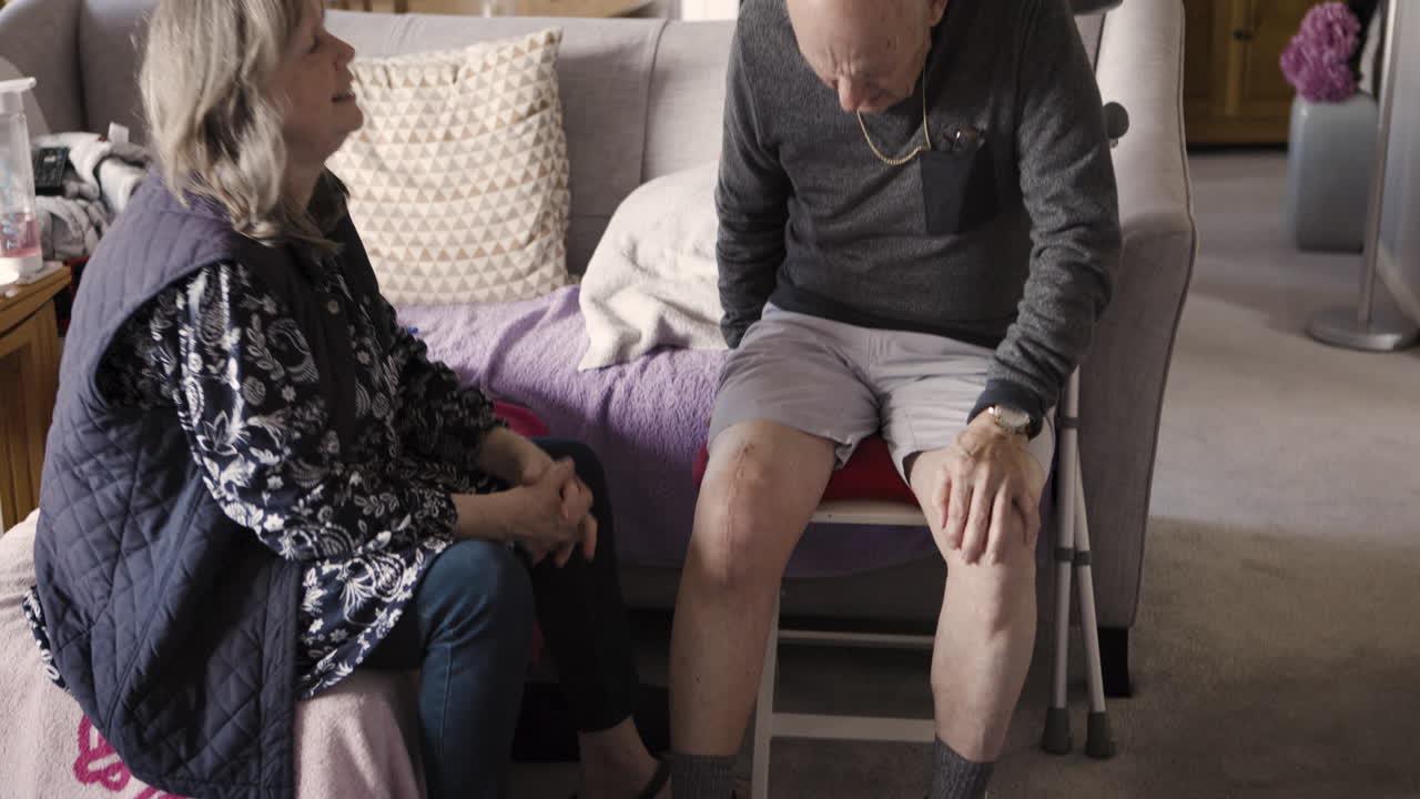 Elderly man and woman at home, possibly caregiver and patient