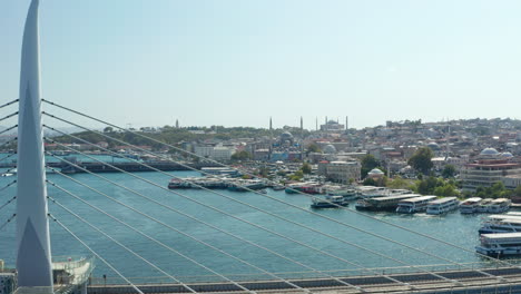 Vista-Panorámica-Del-Puente-Con-La-Estación-De-Tren-De-Transporte-Público-En-Estambul,-Mezquita-Que-Revela-El-Avance-Aéreo-En-La-Orilla-Del-Río