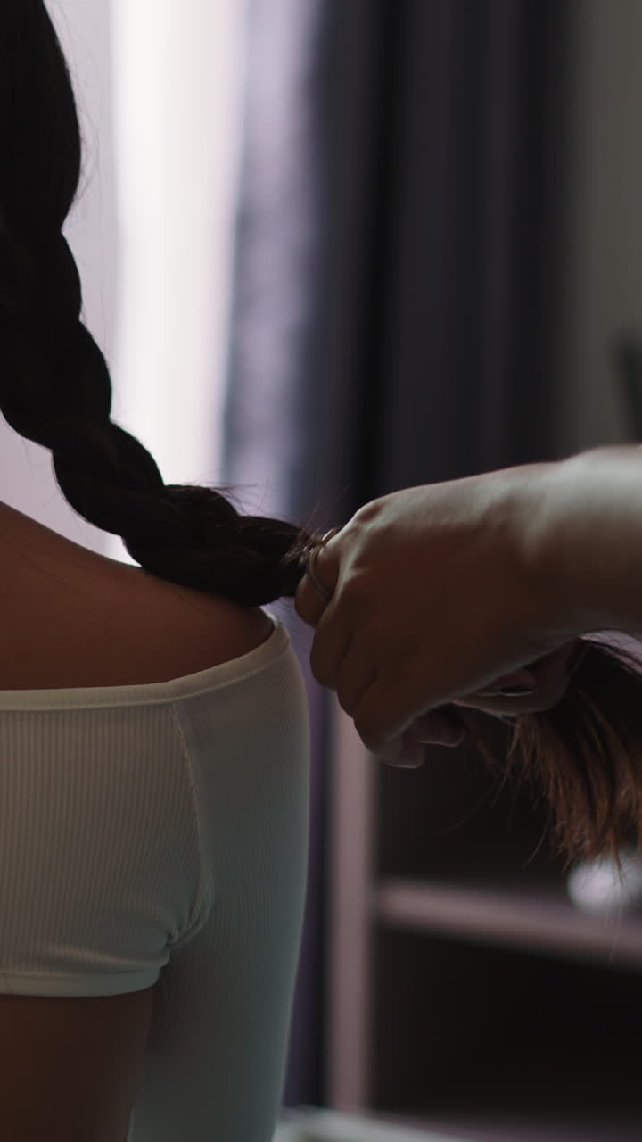 Close-up of Hands Braiding Long Dark Hair