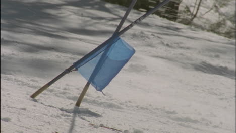 a skier speeds past a toppled flag