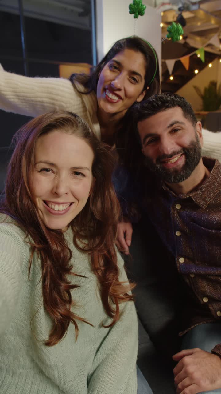 Video verticale di amici che si vestono a casa o al bar, festeggiano a una festa di San Patrizio e posano per un selfie al telefono in tempo reale.