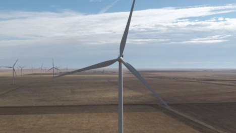 Antena-Estática-De-Una-Turbina-Eólica-Giratoria-En-El-Norte-De-Texas,-EE.UU.-Con-Otras-Turbinas-Girando-En-El-Fondo