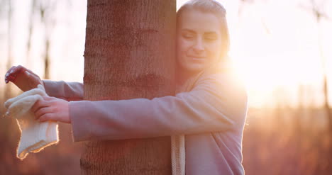 beautiful loving nature woman hugs tree in forest in autumn 2