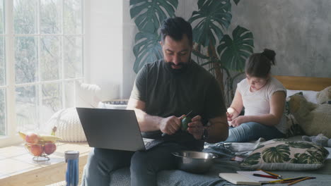 father working from home while daughter studies