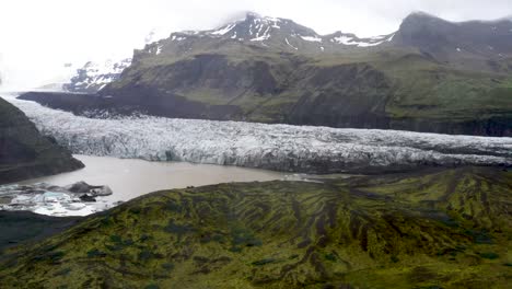 glaciar de islandia con colinas verdes con video de drones moviéndose hacia los lados