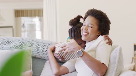 Smiling-african-american-daughter-giving-happy-mother-a-mother's-day-gift,-slow-motion