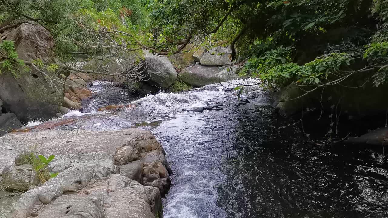 agua que fluye de la cascada en el pequeño sendero de hawaii, tseung kwan o, hong kong