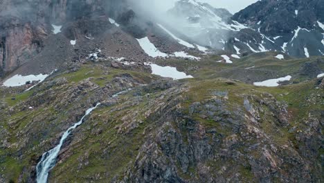 Misty-mountain-landscape-with-Cascata-di-Stroppia-and-Lago-Niera,-aerial-view,-in-summer