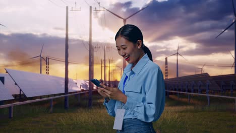 side view of asian female with her smartphone with solar panel and wind turbines, checking on her smartphone with meditation