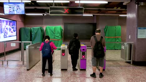 Early morning commuters queue in line as they wait for the MTR subway station to open for its first train of the day