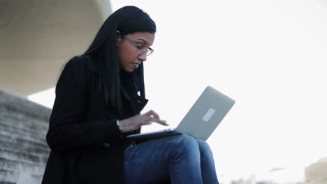 Slow-motion-shot-of-confident-businesswoman-typing-on-laptop-outdoor