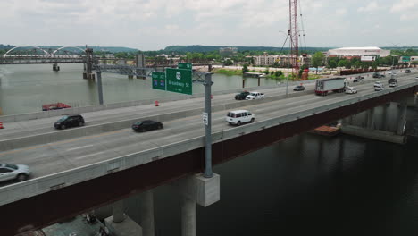 Interstate-30-I-30-traffic-crosses-Arkansas-River-Bridge,-Little-Rock,-AR---Aerial-slide-left