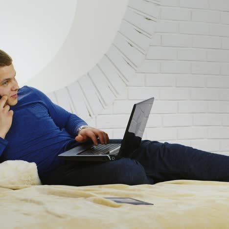 young man casually using a phone and laptop