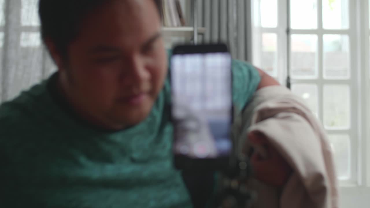 Asian Man Shows Trick With Disappearing On Mobile Phone Camera While Recording On Smartphone Video Content For Social Networks In Cozy Room