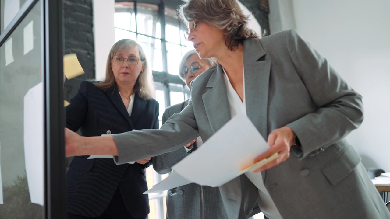 Three Professional Women Collaborating on a Project in a Modern Office