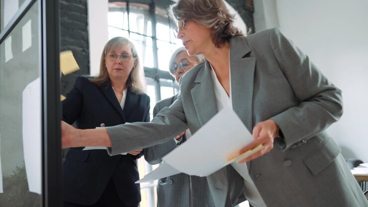 Three Professional Women Collaborating on a Project in a Modern Office