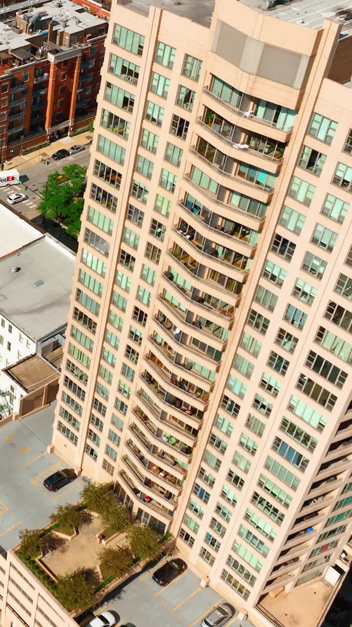 Chicago, Illinois, USA - June 01, 2024: Aerial top view of urban city with rooftop parking, roads with cars and subway lines. Vertical video