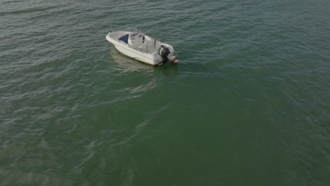 isolated small white boat aerial view on ocean lake bay water