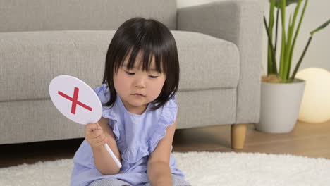 girl holding a correct answer panel in her hand