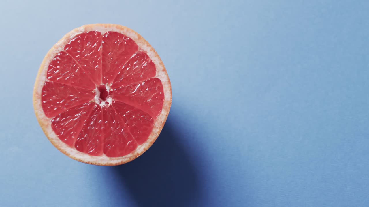 Video di pompelmo rosso affettato con spazio per il testo su sfondo blu