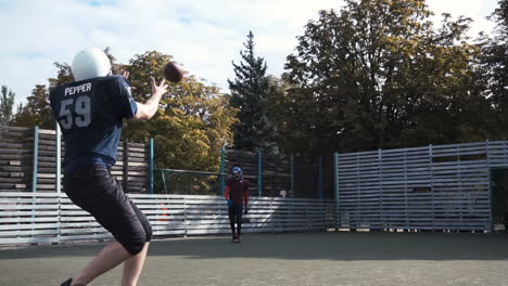 american football practice: players training and throwing on a field