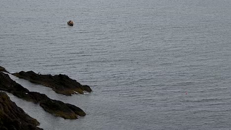 Barco-Flotando-Hacia-El-Castillo-De-Dunnottar,-Escocia,-Reino-Unido