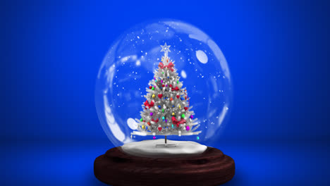 digital animation of snow falling over christmas tree in a snow globe against blue background