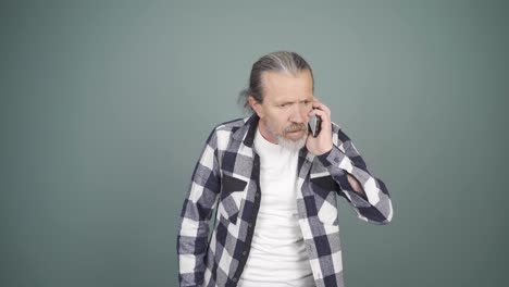 man getting bad news on the phone gets upset.