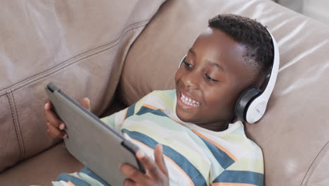 african american boy enjoys digital entertainment at home using a tablet