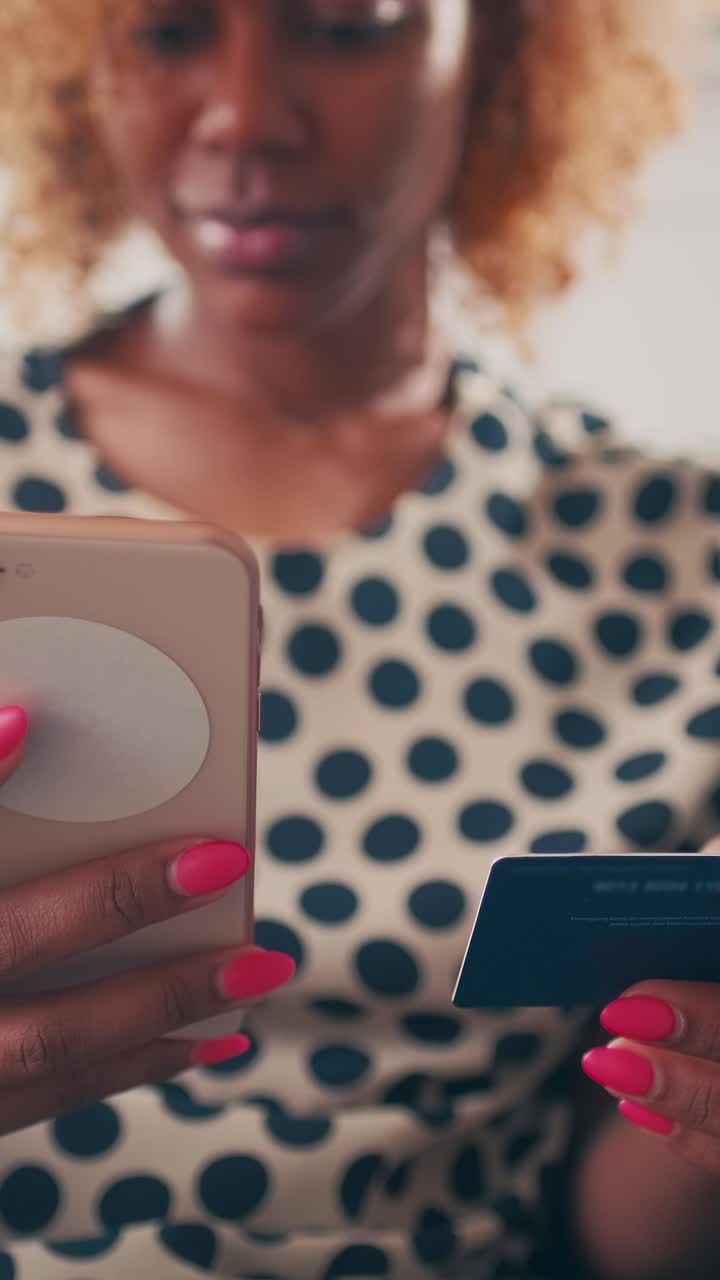 Casual ethnic african american woman holds credit card and phone