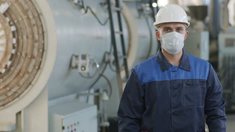 worker in face mask posing in factory