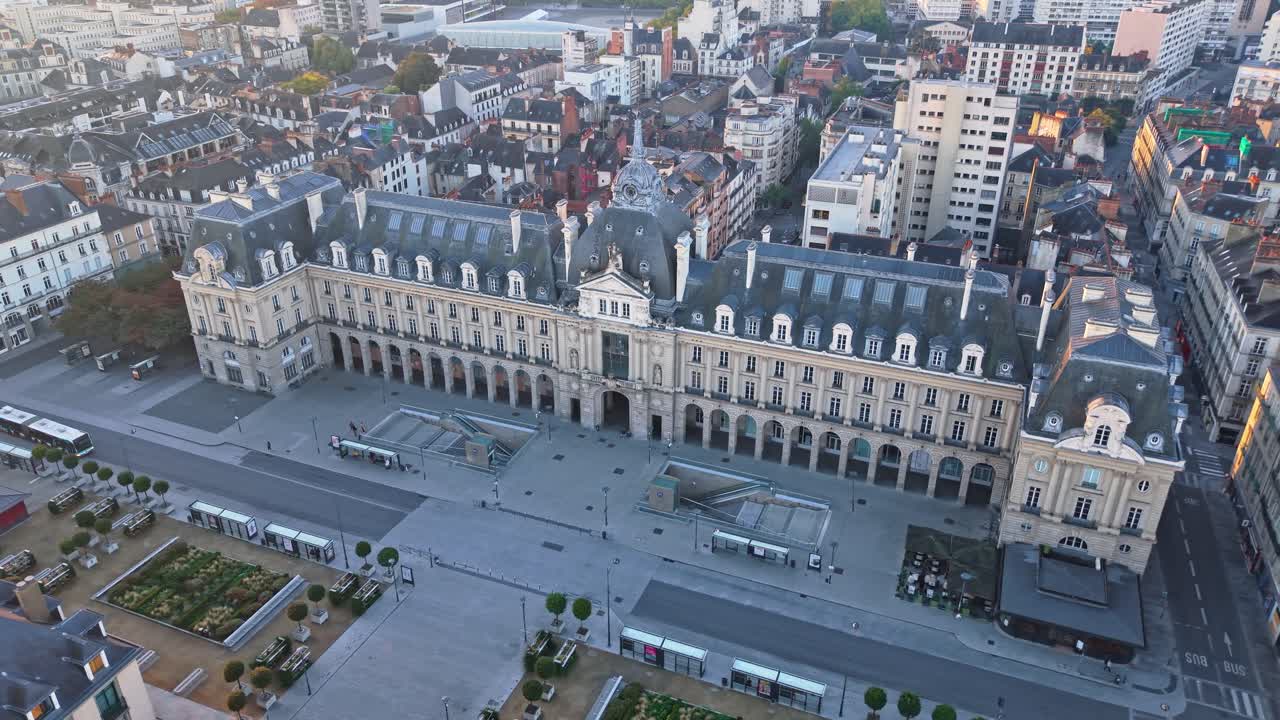 Drone panning then circling over Palais du Commerce on Place de la République in Rennes, France at sunrise