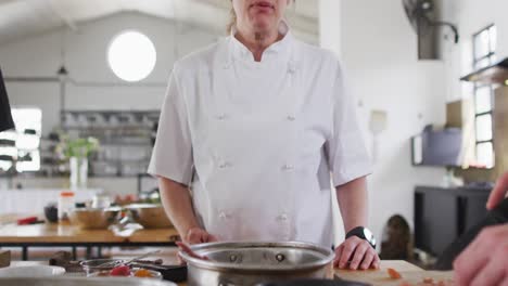 Caucasian-female-chef-teaching-diverse-group