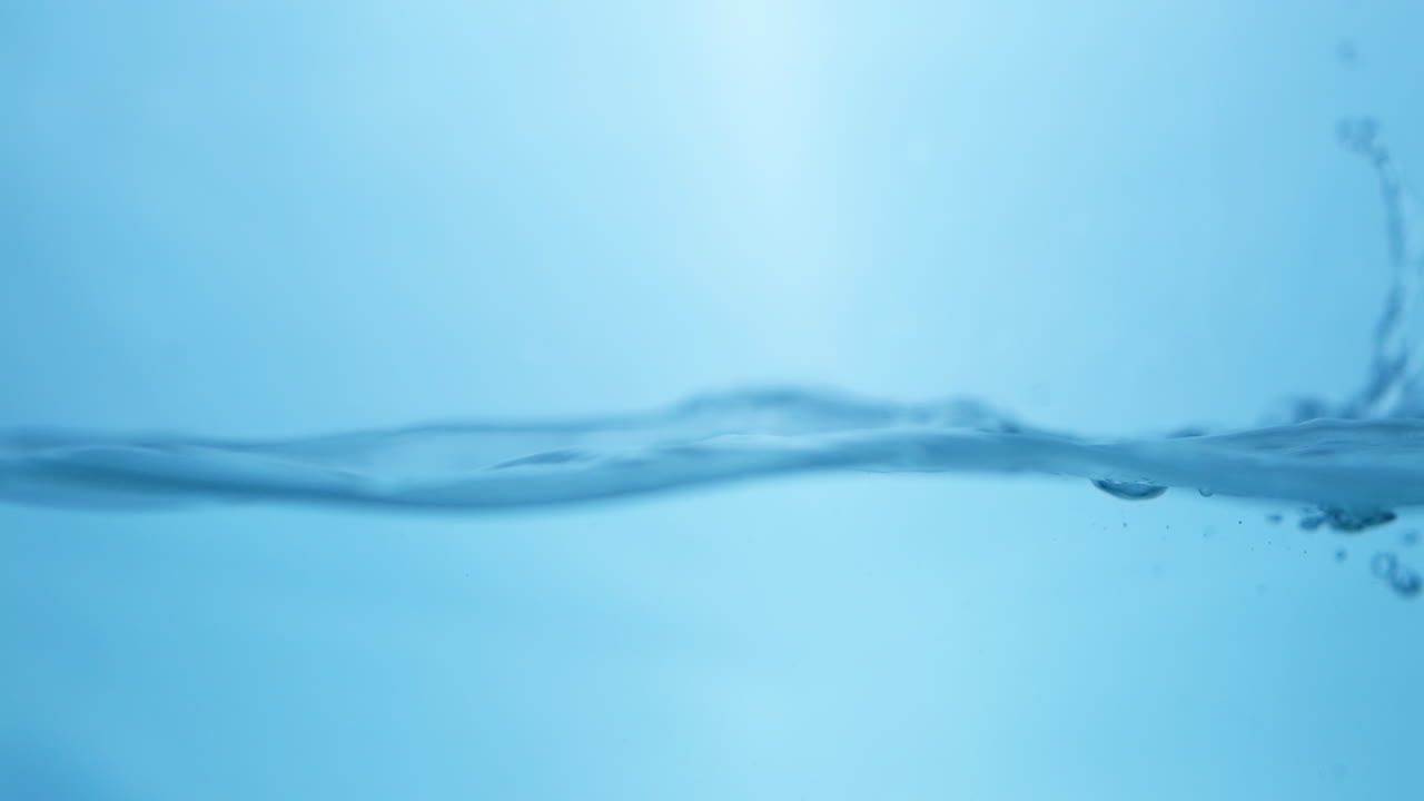 파란색 배경으로 표면에 있는 물의 파도_ 느린 움직임