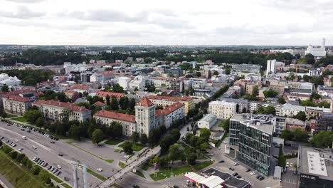 Edificio-Moderno-Y-Antiguo-Que-Se-Mezcla-En-El-Horizonte-De-La-Ciudad-De-Kaunas,-Vista-Aérea-De-Drones