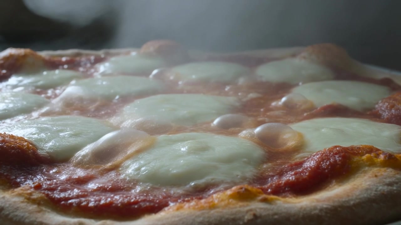 Pizza Margherita fumante che si scioglie dal forno con mozzarella che si ammorbidisce e bolle su un piatto rotondo.
