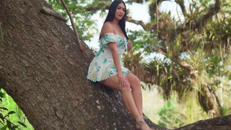 Una-Joven-Sentada-En-Un-Gran-Tronco-De-árbol-Con-Un-Vestido-Corto-En-Un-Parque-En-Un-Día-Soleado