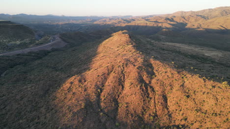 peak of desert hill lit by the morning sunrise
